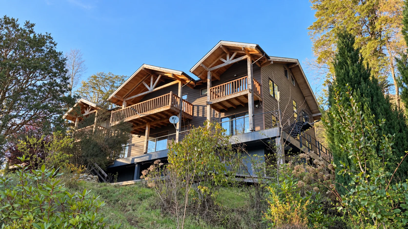 Casa de madera con balcones rodeada de árboles y jardín